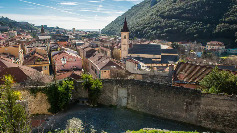 Tetti e campanile di Finalborgo tra le montagne