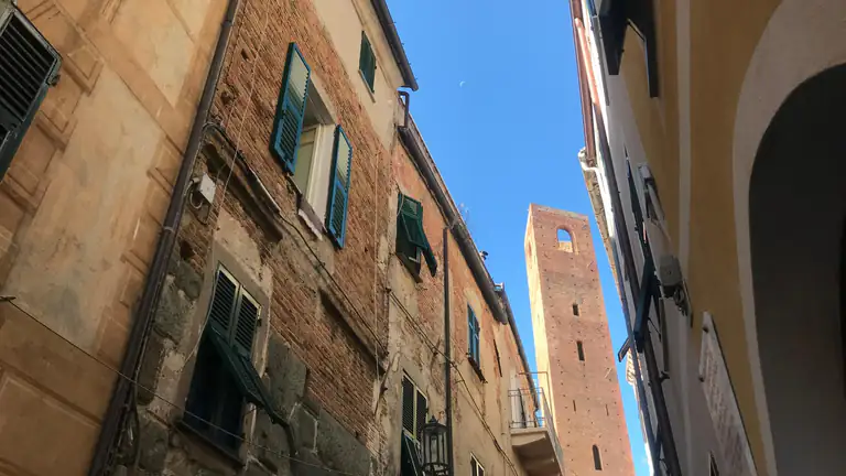 Carruggio e torre medievale nel centro storico di Noli