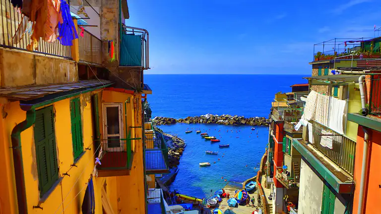 Colourful houses and harbour of Riomaggiore seen from an alley