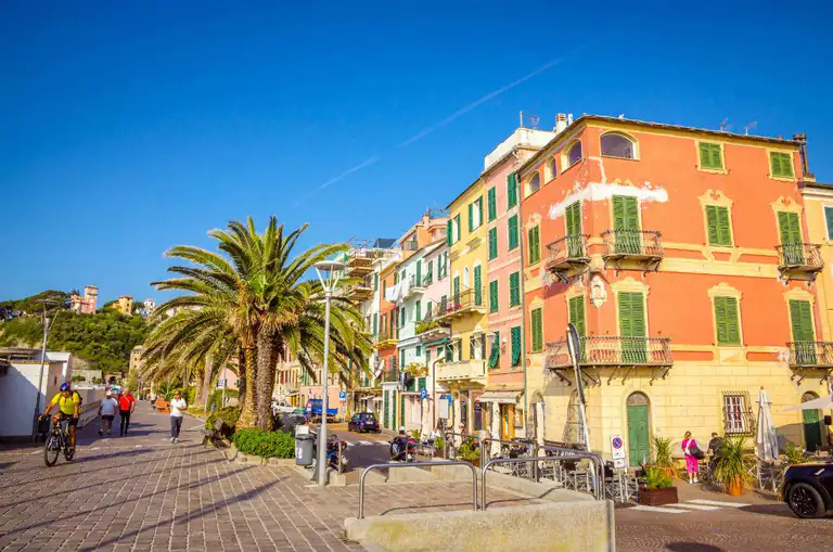 Lungomare con palme e palazzi colorati a Celle Ligure
