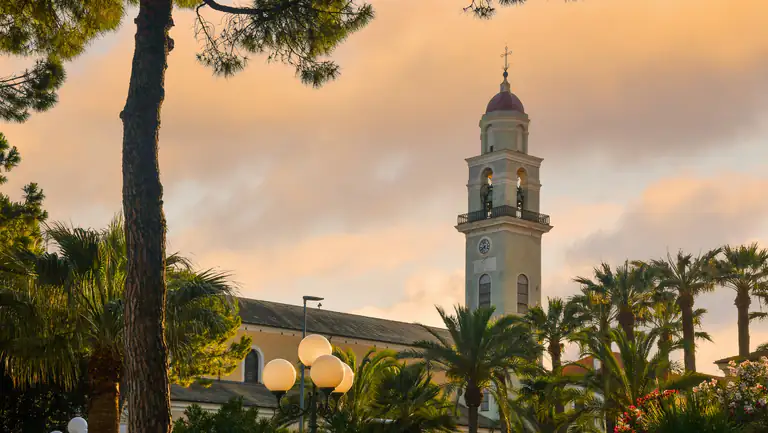 Campanile tra le palme a Diano Marina al tramonto
