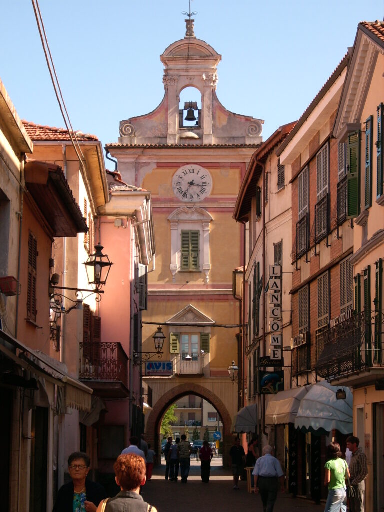 Una porta con orologio e campanile su una via del centro storico di Cairo Montenotte