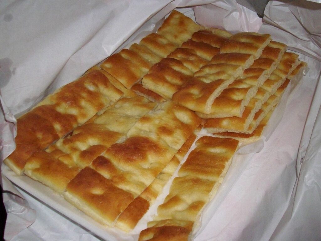 Focaccia genovese tagliata a strisce, dorata e alveolata