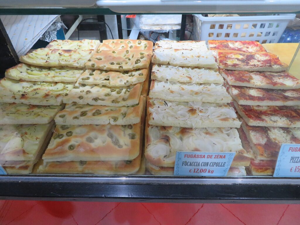 Focaccia genovese in vendita in un panificio di Genova, con cipolle e olive