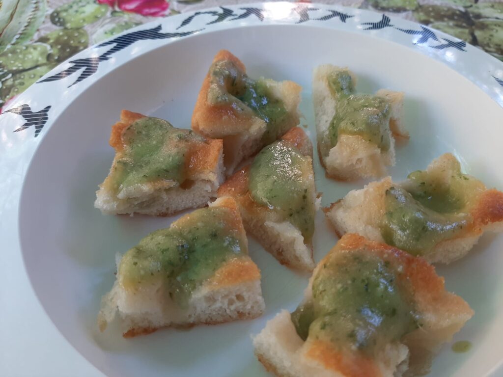 Focaccia genovese tagliata a pezzi con il pesto sopra