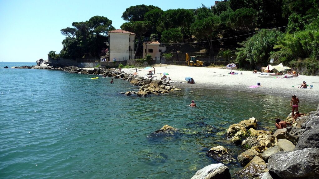 La spiaggia tra gli scogli e i pini a Bocca di Magra