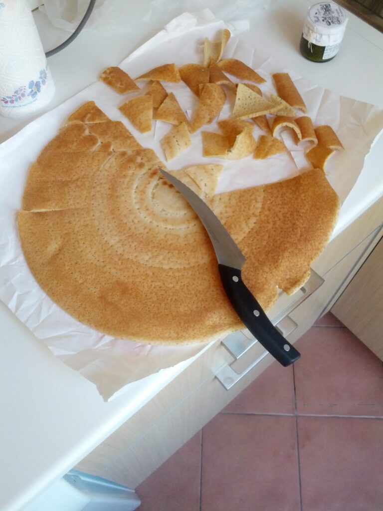 Un testarolo fatto in casa mentre viene tagliato a pezzi