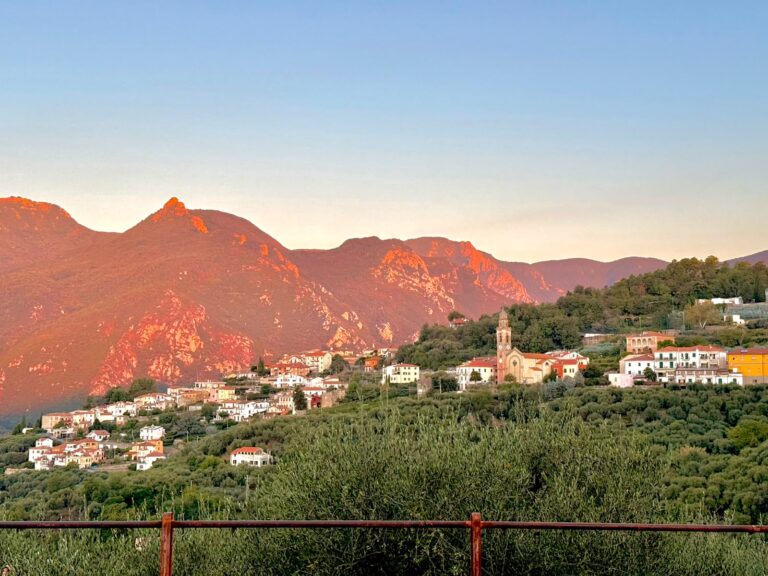 Bardino Nuovo al tramonto, con il campanile di San Sebastiano e le montagne sullo sfondo